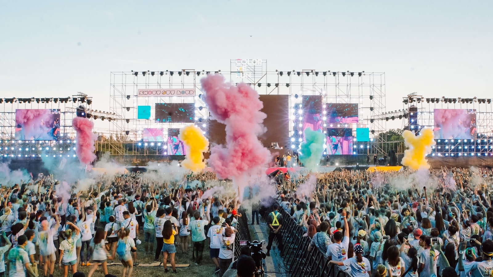 Attendees spread across a festival field on a sunny day